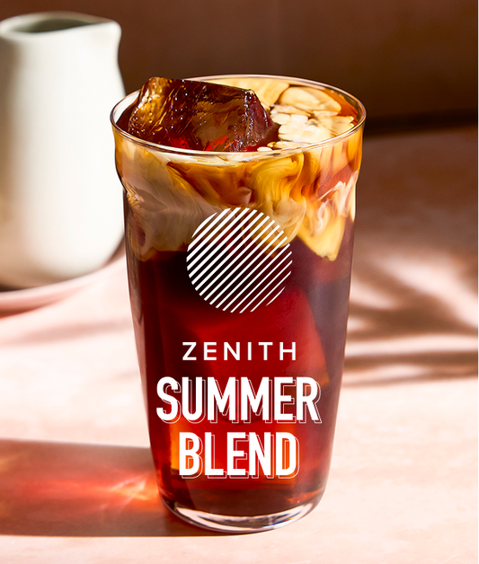 Glass of iced coffee with 'Zenith Summer Blend' label on a wooden surface